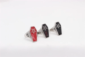 Detailed view of red and black coffin-shaped rings with engraved pentagram design