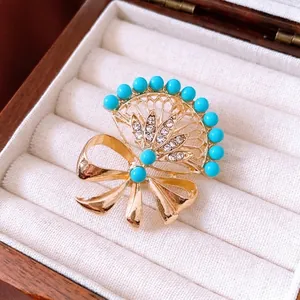 Vintage gold fan-shaped bow brooch with turquoise beads and crystal accents
