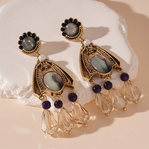 Detail of vintage French style earrings with teardrop crystals and gold metal texture