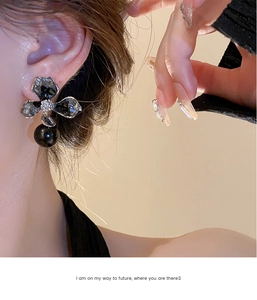 Macro detail of asymmetric crystal flower earring with a large black pearl drop