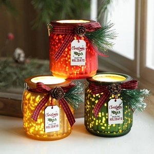Three Christmas glass LED candle lanterns with pinecones and festive ribbon bows
