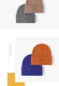 Detailed knit texture and smiley face embroidery on versatile winter beanies in four colors