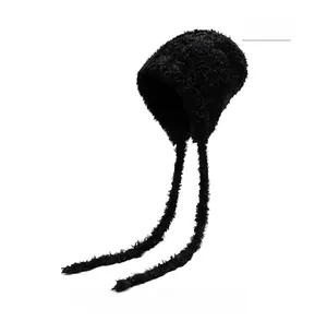 Detail of black plush earflap hat with long ties and soft faux fur texture