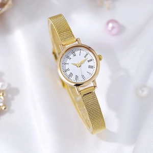 Macro detail of gold mesh strap and white dial with roman numerals on silk background