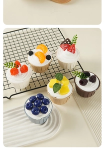 Detailed close-up of realistic artificial cupcakes with assorted fruit toppings and cream texture