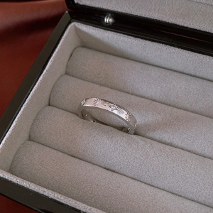 Close-up of silver brushed star ring with white zircons on premium grey velvet jewelry box