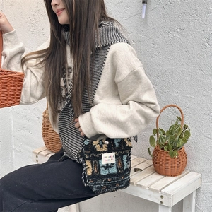 Detailed shot of plush crossbody bag with vintage floral pattern and woven strap detail