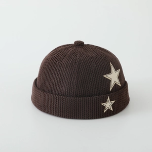 Detailed view of dark brown corduroy texture and white star patch on the kids Miki hat