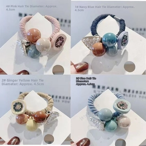 Detail view of colorful elastic hair ties with resin beads and pearls in four color styles