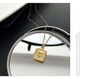 Macro view of golden square butterfly pendant with shell inlay and hammered texture
