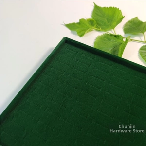 Macro shot of dark green velvet jewelry tray with slots for ring and earring display