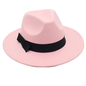 Detail view of pink felt fedora hat featuring a smooth wool texture and black ribbon bow