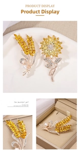 Detailed close-up of crystal wheat ear and sunflower brooches with pearl accents