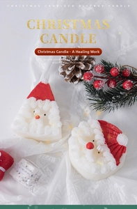 Detail of Santa Claus scented candles with festive pine cones and berry decorations
