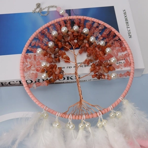 Close-up of tree of life dreamcatcher with orange crystals and soft white feathers