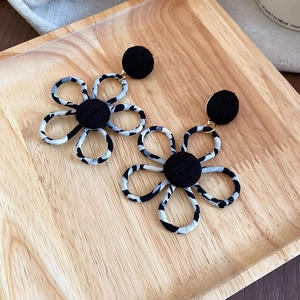 Détails des boucles d'oreilles fleurs léopard avec centres en velours et finitions dorées