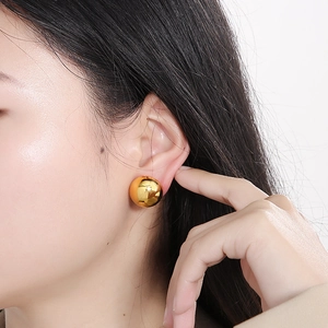 Classic minimalist golden hollow spherical stud earrings for women on model's ear