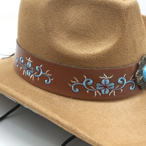 Close-up of Western felt cowboy hat with floral embroidered leather band and turquoise stud