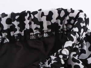 Dettaglio ravvicinato dell'elastico in vita della gonna in chiffon con stampa mucca b/n