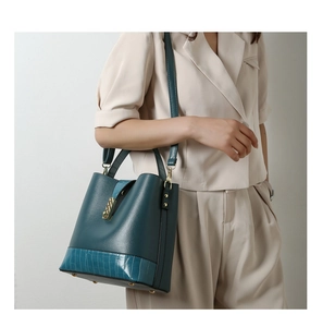 Detail of dark teal bucket bag with lychee pattern and crocodile texture paneling