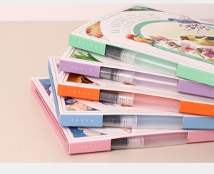 Detailed set of five colorful watercolor coating books with brushes on beige background