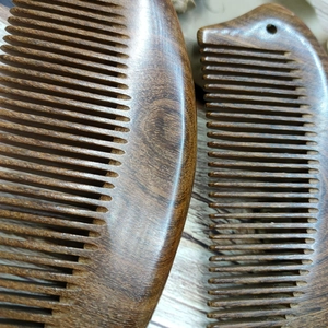 Close-up of a handcrafted sandalwood comb showcasing natural wood grain and polished texture