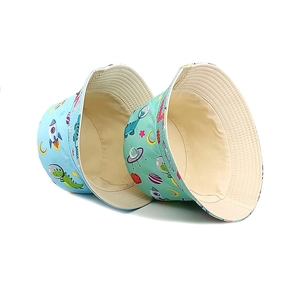 Kids dinosaur space bucket hats in light blue and green with cartoon rocket prints