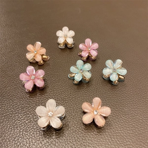 Close-up of translucent flower hair claws with pearlescent finish and rhinestone centers