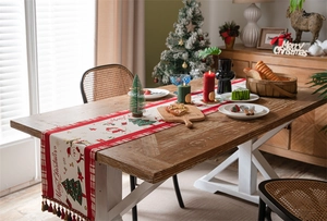 Close-up of Christmas table runner with festive snowman patterns and colorful tassels