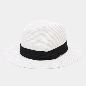 Close-up of fine spiral woven texture on white straw hat with black satin ribbon band