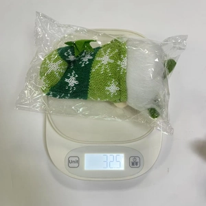 Weight measurement showing a 32.5g Christmas knitted doll with green snowflake cloak
