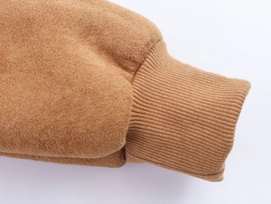 Gros plan d'une manche de veste aviateur en suédine marron avec poignet en tricot