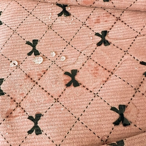 Detailed close-up showing water-resistant pink fabric with a bow and diamond pattern