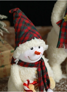 Close-up of plush Christmas snowman ornament with red and green plaid scarf and soft texture