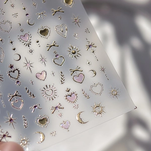 Macro shot of metallic relief nail stickers with gold heart star moon and bow designs
