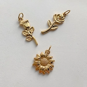 Tre ciondoli vintage in acciaio inossidabile dorato a forma di fiori, rose e girasole