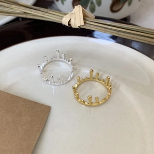 Detail of gold and silver melted crown rings on a white ceramic tray with rustic decor