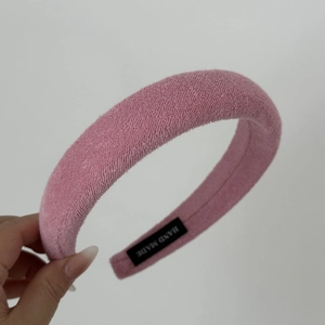 Pink terry cloth headband with black HAND MADE label detail and soft texture