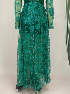 Detail of emerald green long sleeve dress with gold sequins and floral embroidery