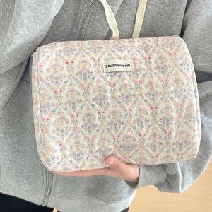 Vue détaillée de la trousse en coton matelassé avec imprimé floral vintage et étiquette
