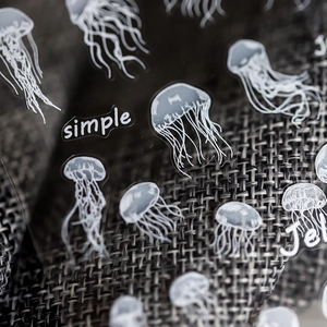 Minimalist white jellyfish nail stickers with matte transparent finish on grey fabric