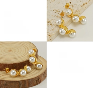 Detailed view of polished gold earrings featuring three pearls in a curved setting