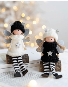 Close-up of knit Christmas angel dolls with silver stars and antlers on wooden bases