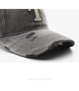 Macro view of distressed grey cotton baseball cap with torn edges and embroidery