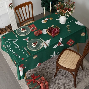 Detailed view of green Christmas tablecloth with Santa, snowman and festive holiday patterns