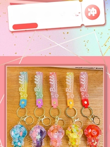Detail view of colorful astronaut keychains with liquid sand effect and PVC wrist straps