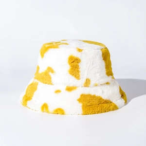 Close-up of fluffy cow print faux fur texture in ginger and white for winter bucket hat