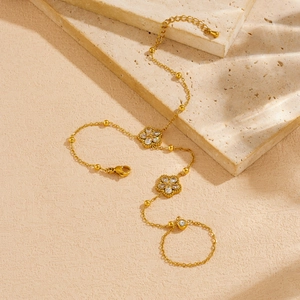 Elegant gold plated floral ring bracelet with sparkling cubic zirconia on marble