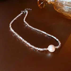 Freshwater pearl necklace with faceted silver beads on dark leather background