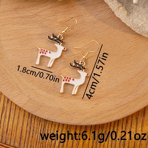 Detailed view of Christmas reindeer hook earrings with size markers and weight on wood